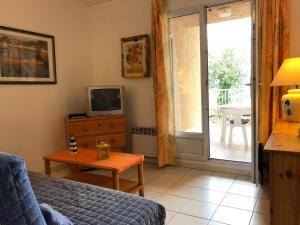 a living room with a couch and a tv and a table at Ferienhaus zw. Cogolin und St. Tropez in Grimaud