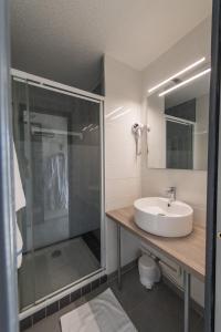 Un baño con lavabo y ducha de cristal. en Arc en Ciel Les Karellis Vacances Bleues- Ski Pass Inclus, en Montricher-le-Bochet