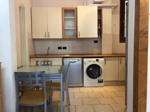 een keuken met een tafel en een wasmachine bij Pizzardi39 - The Place Apartments in Bologna