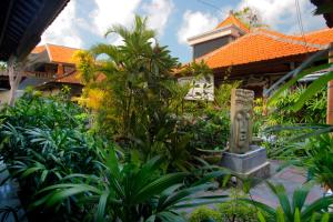 a garden with a statue in front of a building at Hotel Jati Sanur in Sanur