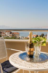 a bottle of champagne on a table on a balcony at Apartments and Rooms Lux in Senj