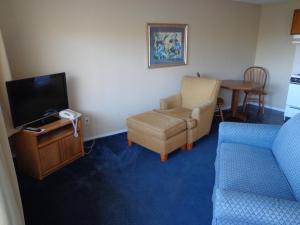 a living room filled with furniture and a tv at Ocean Shores Inn & Suites in Ocean Shores