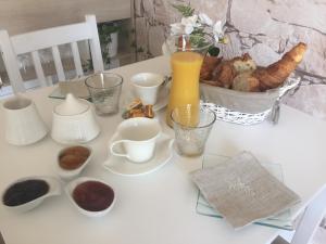 a white table with cups and other items on it at Au charmant des vignes in Montagne