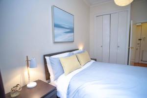 アバディーンにあるModern Flat in Rosemount/City Centreのベッドとランプ付きのテーブルがある寝室