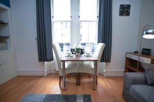 アバディーンにあるModern Flat in Rosemount/City Centreのダイニングルームテーブル(窓際の白い椅子付)