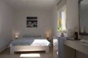 a white bedroom with a bed and a window at Apartments and Rooms Lux in Senj