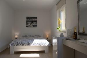 biała sypialnia z łóżkiem i oknem w obiekcie Apartments and Rooms Lux w mieście Senj