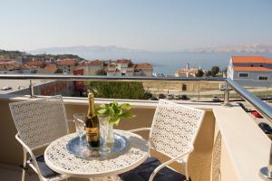 einen Tisch mit einer Flasche Wein auf dem Balkon in der Unterkunft Apartments and Rooms Lux in Senj