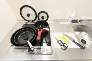 a kitchen counter with a frying pan and scissors at Stay SAKURA Kyoto Shijo Karasuma in Kyoto