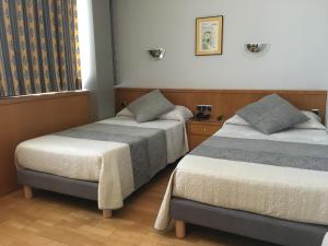 um quarto com 2 camas e uma janela em Encasa Hotel Almansa em Almansa