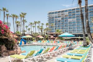 a pool with lounge chairs and a hotel at Isla Grand Beach Resort in South Padre Island