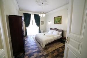 een slaapkamer met een bed en een kroonluchter bij Del Rey Luxury in Lviv