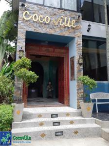 a building with a sign that reads coco villa at Cocoville Phuket - SHA Plus in Chalong 