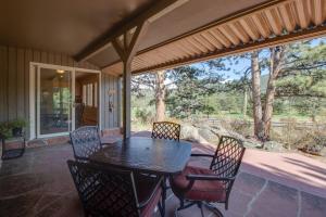 a patio with a table and chairs on a porch at Cottage of Course - Permit #3092 in Estes Park