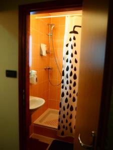 a bathroom with a shower with a black and white shower curtain at Hostel Savski Most in Zagreb