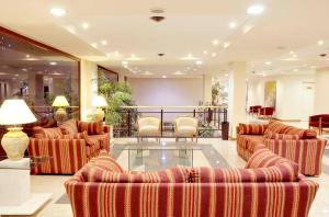 a lobby with couches and a table and chairs at Hotel Argos in Bahía Blanca