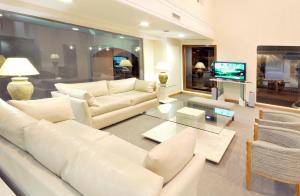 a living room with white furniture and a tv at Hotel Argos in Bahía Blanca