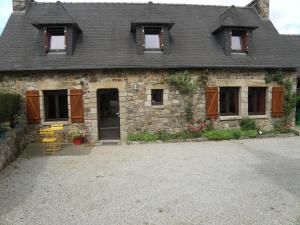 une maison en pierre avec des chaises et des tables devant elle dans l'établissement Kerbaliou, à Crozon