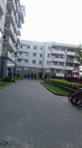 ビャウィストクにあるAntoniukowska-apartamentの白い大きな建物で、正面に自転車が停まっています。