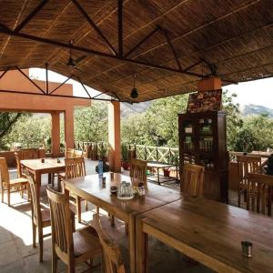a large wooden table and chairs on a patio at Krishna Ranch in Udaipur