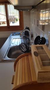 - un évier de cuisine avec une planche de coupe en bois à côté dans l'établissement Ferienwohnung Apres Ski, à Schruns