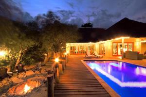 a backyard with a swimming pool at night at Casart Game Lodge in Grietjie Game Reserve