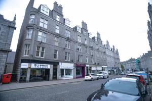 um edifício numa rua com carros estacionados em frente em Modern Flat in Rosemount/City Centre em Aberdeen