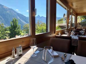 ein Restaurant mit einem Tisch und Bergblick in der Unterkunft Hotel Sonnenhalde in Wiesen