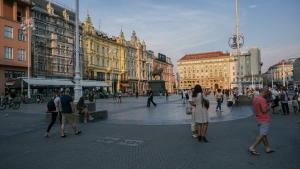 a group of people walking around a city square at Karlo Main Square Apartments in Zagreb