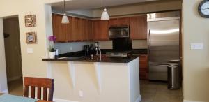 a kitchen with wooden cabinets and a stainless steel refrigerator at Vacation Home in Ko Olina Resort in Kapolei