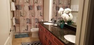 a bathroom with two sinks and a toilet and a shower curtain at Vacation Home in Ko Olina Resort in Kapolei