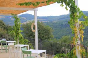 a patio with tables and chairs and a view of mountains at Pekko in Spello