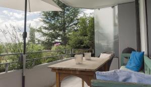 einen Tisch und Stühle auf einem Balkon mit Sonnenschirm in der Unterkunft Seesterne Comfort in Konstanz