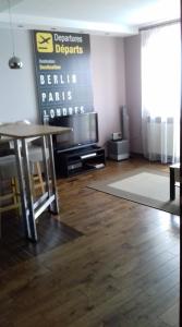 ビャウィストクにあるAntoniukowska-apartamentのリビングルーム(テーブル、テレビ付)