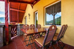 a dining room with a table and chairs on a porch at Raza Soarelui Pension in Praid