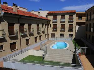 薩拉曼卡的住宿－Apartamento turisticos Puente Romano P3 2-A，享有庭院内一座带游泳池的建筑的顶部景色
