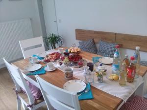 een houten tafel met borden en fruitschalen erop bij Ferienwohnung "EDELweiß" in Inzell