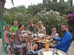 a group of people sitting around a table at Riad-villa Le Jardin aux Etoiles in Sidi Boumoussa