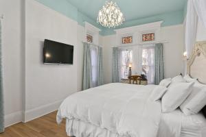 a bedroom with a white bed and a tv on a wall at Patterson Inn in Denver