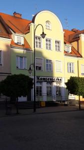 a yellow building with a street light in front of it at Kamieniczka in Nidzica