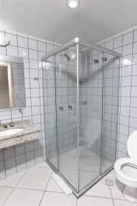 y baño con ducha de cristal y aseo. en Hotel Express São Leopoldo, en São Leopoldo