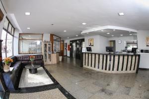 a lobby of a hospital with a couch and a counter at Hotel Suárez São Leopoldo in São Leopoldo