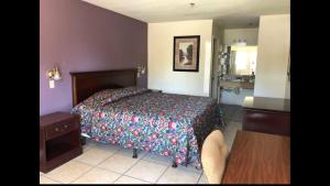 a bedroom with a bed and a table and a kitchen at Sand Piper Motel - Los Angeles in Los Angeles