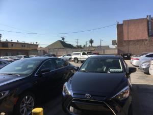 a couple of cars parked in a parking lot at Sand Piper Motel - Los Angeles in Los Angeles