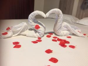 dois cisnes feitos de corações numa cama em Hotel Cliché em San Lucido
