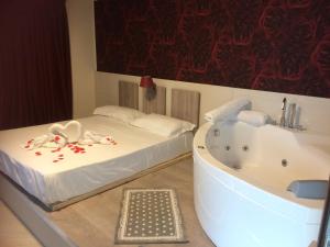 - une chambre avec un lit et une baignoire dans l'établissement Hotel Cliché, à San Lucido