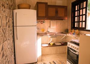 uma cozinha com um frigorífico branco num quarto em Trindade Hospeda - Casa 2 - 20 Passos da Areia em Trindade