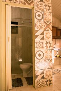 uma casa de banho com um WC e uma parede em azulejo em Trindade Hospeda - Casa 2 - 20 Passos da Areia em Trindade