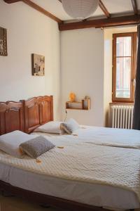 um quarto com 2 camas com lençóis brancos e uma janela em Le gîte du chateau dans le centre de schirmeck em Schirmeck