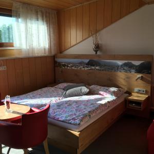 ein Schlafzimmer mit einem Bett, einem Tisch und einem sidx sidx in der Unterkunft Pension Nocksteinblick in Salzburg